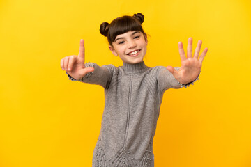 Wall Mural - Little caucasian girl isolated on yellow background counting seven with fingers