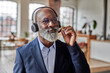 © Westend61 - Businessman listening through headset at home