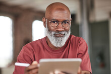 Mature Man With Beard Holding Tablet PC At Home