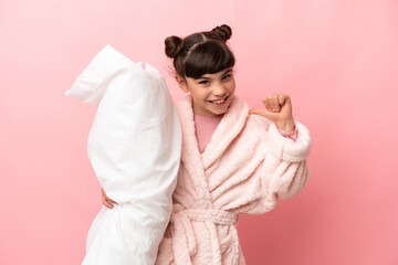 Wall Mural - Little caucasian girl isolated on pink background in pajamas and proud of self-satisfied