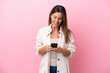 © luismolinero - Middle age caucasian woman isolated on pink background sending a message with the mobile