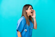 © luismolinero - Middle age surgeon woman isolated on blue background shouting with mouth wide open to the lateral