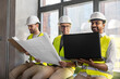 © Syda Productions - architecture, construction business and people concept - male architects in helmets with laptop, blueprint and clipboard working at office