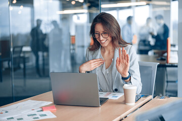 Wall Mural - Confident deaf businesswoman communicating in video call with client at workplace in modern office.