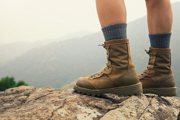 Wall Mural - suceesful woman hiker legs stand on mountain peak cliff edge