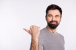 © Tetiana - Profile side photo of young guy look indicate thumb empty space recommendation ads isolated over grey color background
