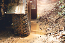 Part Of An Off-road Vehicle On A Dirt Road With Warm Light. Adventure Concept.Tire Off-road On Mud 