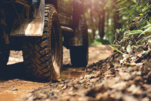 Part Of An Off-road Vehicle On A Dirt Road With Warm Light. Adventure Concept.Tire Off-road On Mud	