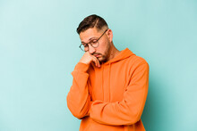 Young Hispanic Man Isolated On Blue Background Tired Of A Repetitive Task.