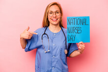 Young Nurse Woman Holding Nurse International Day Isolated On Pink Background Person Pointing By Hand To A Shirt Copy Space, Proud And Confident