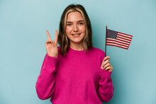 Young Caucasian Woman Holding A American Flag Isolated On Blue Background Showing Number Two With Fingers.