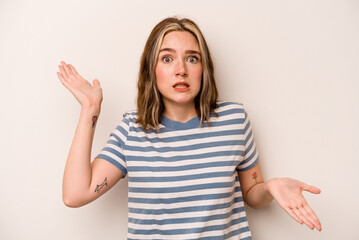 Young caucasian woman isolated on white background confused and doubtful shrugging shoulders to hold a copy space.