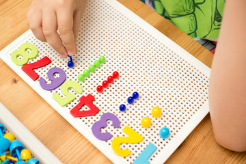 Wall Mural - By provided numbers boy inserting pins. counting game. mathematical task. play at home. way of learning.