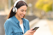Happy Woman Listens To Music Or Is Watching Media On Phone