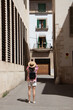 © paulomachado_9 - Young woman traveler with her straw hat taking pictures of the architecture of the houses on the balearic island of Palma de Mallorca, Spain