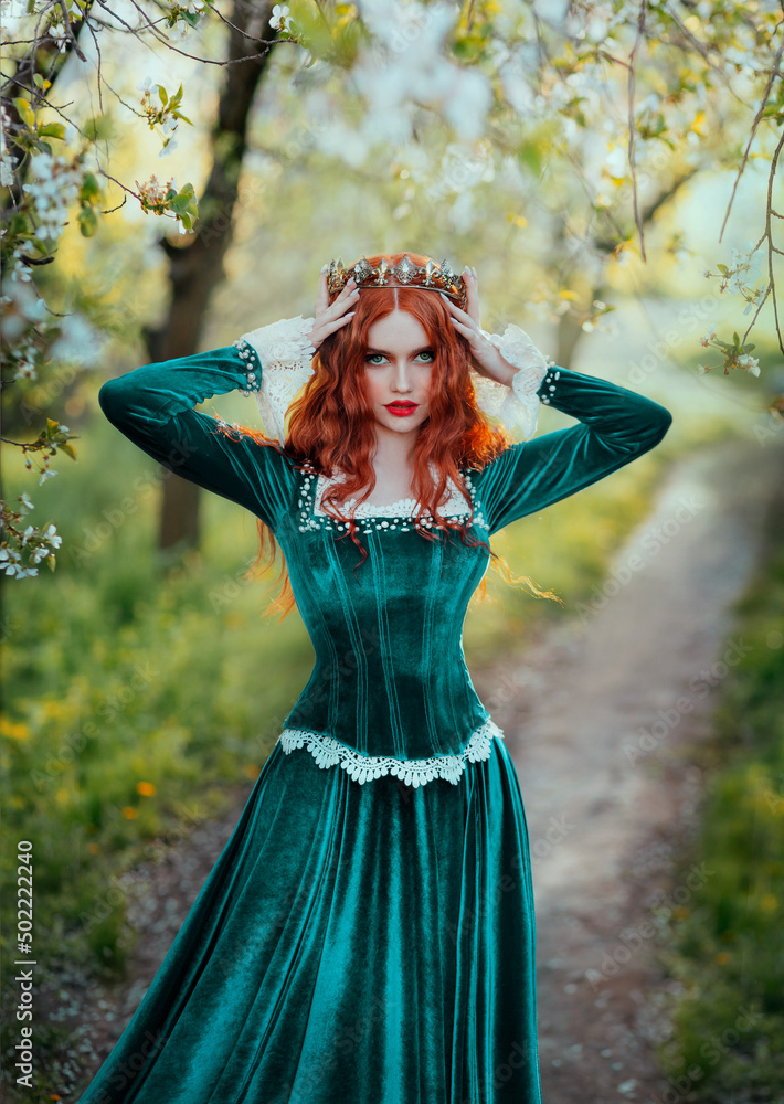 Portrait fantasy red-haired woman medieval queen touches with hands  straightens golden crown on head. Girl redhead princess. Green vintage long  dress curly hairstyle. Summer nature garden forest trees Stock Photo | Adobe