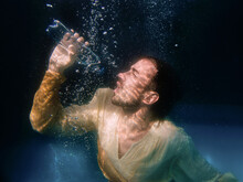 An Underwater Shot Of A Man Drinking Water In A Swimming Pool On Black Background