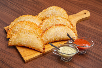 Wall Mural - fried pastry, fogazza, meat pastry, cheese pastry, served with mayonnaise and chili sauce, timico Brazilian bar snack.