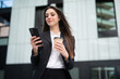 © Minerva Studio - Businesswoman using her smartphone in a modern city square