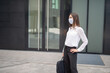 © Minerva Studio - Masked woman walking in a city park