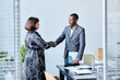 © Seventyfour - Portrait of African American business advisor shaking hands with female client after meeting in office
