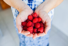 Hands Of A Woman Holding Handful Of Fresh Raspberries - Pregnancy Cravings