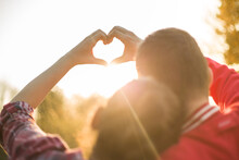 Beautiful Relationship Between Boy And Girl, Women And Men. Love Is In The Air. They Are In Love. I Love You. Two Persons Showing Heart By Hands In Amazing Summer Sunset Warm Light. 