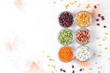Legumes And Beans Assortment, Healthy Vegan Protein Food, Mixed Dried Legumes And Cereals Isolated On White Background, Top View With Copy Space, Legumes And Beans Assortment In Different Bowls.