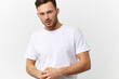 © SHOTPRIME STUDIO - Serious angry young tanned handsome man in basic t-shirt fold hands posing isolated on over white studio background. Copy space Banner Mockup. People emotions Lifestyle concept