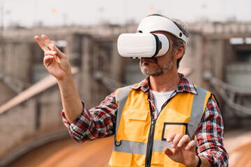 Senior engineer wearing AR goggle and browsing work area thought the virtual reallity. Technology Virtual reallity for industrial work space.