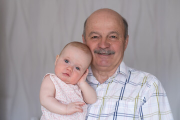 Grandfather holding a caucasian 8 month baby girl