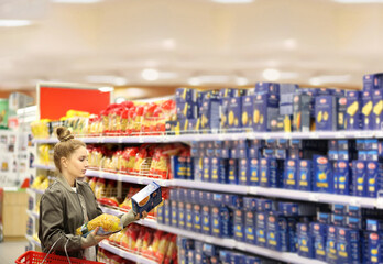 Wall Mural - Woman choosing a dairy products at supermarket