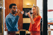 © Samuel Perales - multiethnic couple look at each other with feeling while drinking red wine from their glasses