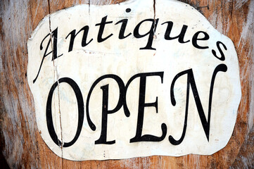 Antique open sign displayed outdoors.