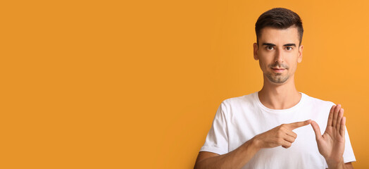 Wall Mural - Young deaf mute man using sign language on orange background with space for text