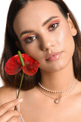 Wall Mural - Young woman holding anthurium flower on white background