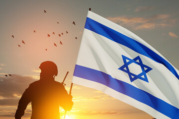 Silhouette of soldier with Israel flag against the sunrise in the desert. Concept - armed forces of Israel. Closeup.