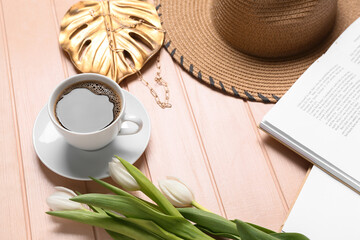 Poster - Opened books, beautiful flowers, cup of coffee and hat on light wooden background, closeup