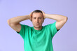 © Pixel-Shot - Shocked mature man in green t-shirt on lilac background