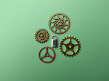 Silver Padlock Mixed Gear Cog DIY Craft Gold And Bronze On A Soft Green Background.