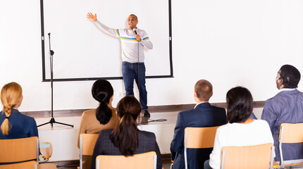 Wall Mural - Emotional male preacher giving motivational speech and worshiping at conference center