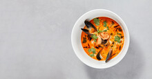 Traditional Asian Food - Tom Yam Kung With Prawn And Mussels. Tom Yum Soup With Seafood And Coconut Milk. Tom Yam In Ceramic Bowl On Gray Stone Background. Oriental Cuisine. Asian Menu.