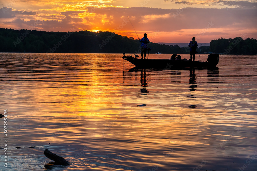 Two men bass fishing in a bass boat on Tims Ford lake in Tennessee with ...