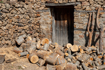 Wall Mural - Stacked firewood heap closeup by rural house wall