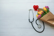 Stethoscope, Heart, Flowers On The Light Wooden Background. International Doctor's Or Nurse's Day. Happy Cardiology Or Heart Day Concept. Thank You Card. Coronavirus. Copy Space