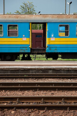 Sticker - Abandoned blue and yellow train carriage and railway tracks