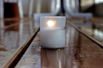 Wall Mural - Lit glass candle jar on a wooden table