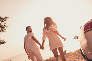 Sticker - Rear back behind view of attractive cheerful couple spending time getaway holding hands looking sunset outdoors