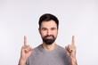 © Tetiana - Photo of young man indicate fingers empty space promotion direct advertising isolated over grey color background