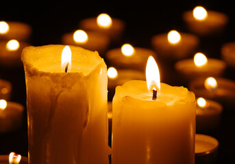 Two burning candles in the dark